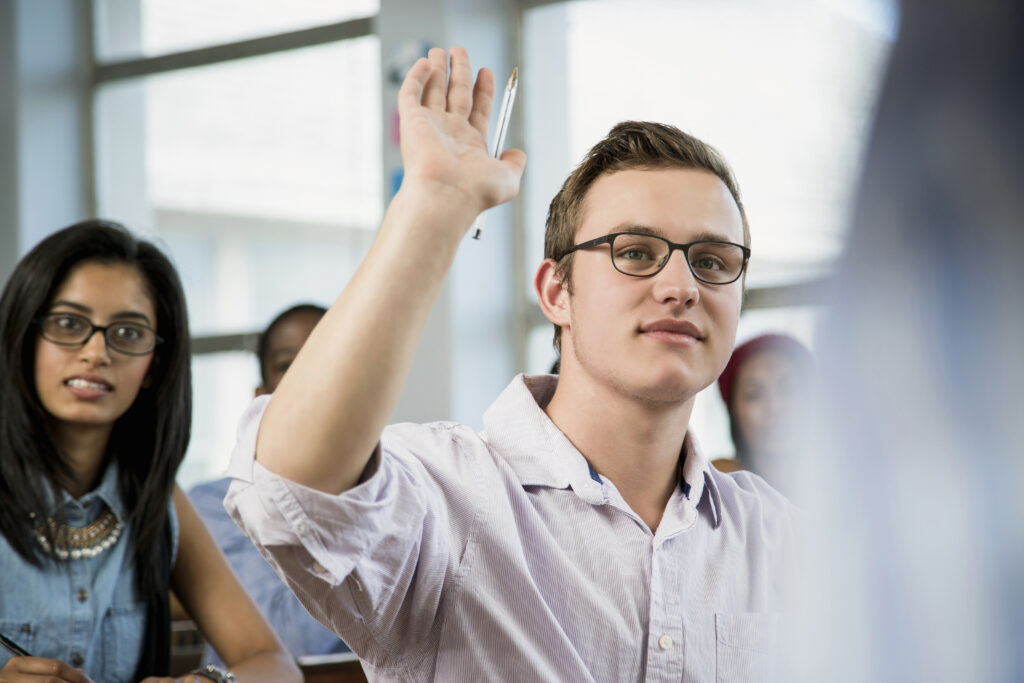A sales intern raising his hand to ask a question.